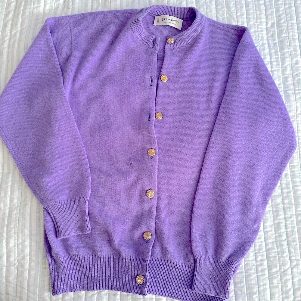 Woman’s lilac colored cardigan with gold buttons
